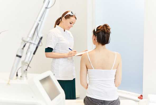 A NAAMA skin therapist talking a client through her tattoo removal plan